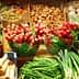 Assorted fresh vegetables including radishes, green beans, and avocados displayed at a market stall. - Olive Oil Times
