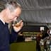 Man holding a glass of olive oil and smelling it during an event. - Olive Oil Times