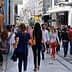 Crowd of people walking on a busy pedestrian street with various shops and advertisements. - Olive Oil Times