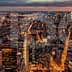 Aerial view of New York City skyline at night with illuminated buildings and streets. - Olive Oil Times