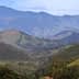 Expansive view of a mountainous landscape featuring rolling green hills and distant peaks. - Olive Oil Times