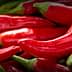 A close-up view of fresh red chili peppers stacked together. - Olive Oil Times