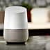 Google Home smart speaker with a white top and gray fabric base on a kitchen countertop. - Olive Oil Times