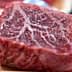 A close-up view of a raw beef cut showcasing marbling in the meat. - Olive Oil Times