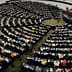 Interior view of the European Parliament with numerous members seated in a circular arrangement. - Olive Oil Times