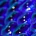 Close-up view of a collection of blue glass bottles arranged in a pattern. - Olive Oil Times
