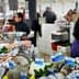 A seafood market featuring various types of fresh fish and seafood on display at vendor stalls. - Olive Oil Times