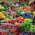 A vibrant assortment of fresh fruits and vegetables arranged at a market stall with price tags. - Olive Oil Times