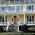 Two-story historic house featuring a large front porch and multiple windows. - Olive Oil Times