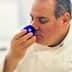 Chef smelling a blue cup during an olive oil tasting session in a professional kitchen. - Olive Oil Times