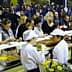 Crowd of people enjoying food at a culinary event with chefs serving dishes. - Olive Oil Times