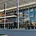 A modern commercial building featuring a glass facade and multiple banners. - Olive Oil Times