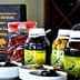 Bottles of olive oil, olives, and other products from Olivicola Simone displayed on a table. - Olive Oil Times
