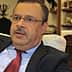 Agriculture Minister Samir Taieb seated in an office with a flag in the background. - Olive Oil Times