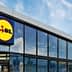 Exterior view of a Lidl supermarket building with large glass windows and a prominent logo. - Olive Oil Times