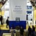 Crowd of attendees at the World Olive Oil Exhibition with a large banner in the center. - Olive Oil Times