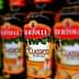 Bottles of Bertolli Classico and Extra Light olive oil lined up on a shelf. - Olive Oil Times