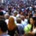 A blurred image showing a large crowd of people walking on a busy street. - Olive Oil Times