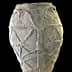 A textured ancient pottery vase with geometric designs and handles on the sides. - Olive Oil Times