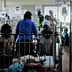 A hospital ward filled with patients in beds and medical staff attending to them. - Olive Oil Times