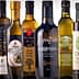 Various bottles of olive oil displayed in a row, featuring different designs and labels. - Olive Oil Times