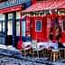 Outdoor café seating with tables and chairs arranged on a cobblestone street in Paris. - Olive Oil Times