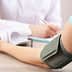 A blood pressure monitor is placed on a patient's arm during a medical consultation. - Olive Oil Times
