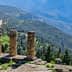 Stone columns of the ancient ruins at Delphi overlooking a mountainous landscape. - Olive Oil Times