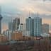 Cityscape of Tehran featuring the Milad Tower and various buildings under a cloudy sky. - Olive Oil Times