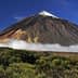 Mount Teide, a prominent volcano in Tenerife, with a snow-capped peak and surrounding clouds. - Olive Oil Times