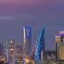Skyline of Riyadh featuring modern skyscrapers illuminated at dusk with a purple sky. - Olive Oil Times