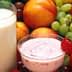 A glass of milk and a bowl of yogurt surrounded by various fruits and vegetables. - Olive Oil Times