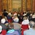 Audience seated in a hall during a literary event with speakers at the front. - Olive Oil Times