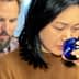 Woman with black hair holding a blue glass to her lips while tasting. - Olive Oil Times