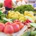 Assorted fresh vegetables including tomatoes, cucumbers, and peppers displayed at a market stall. - Olive Oil Times