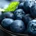 A bowl filled with fresh blueberries and mint leaves on top. - Olive Oil Times