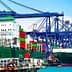 Two large container ships docked at a port with colorful shipping containers stacked on them. - Olive Oil Times