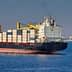 Large container ship with stacked cargo containers sailing in open water. - Olive Oil Times