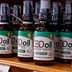 Row of CBD oil bottles with various labels displayed on a wooden shelf in a store. - Olive Oil Times