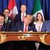 Political leaders signing the USMCA agreement at a table with flags of the US, Canada, and Mexico in the background. - Olive Oil Times