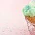 Three ice cream cones with green, pink, and yellow ice cream topped with colorful sprinkles. - Olive Oil Times