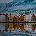 Row of colorful waterfront houses reflecting in the water in Bergen, Norway during winter. - Olive Oil Times