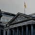 The Congreso de los Diputados building in Spain with a statue in front and a flag on top. - Olive Oil Times