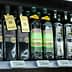 Various bottles of extra virgin olive oil displayed on a store shelf with labels and branding. - Olive Oil Times