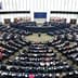 Interior view of the European Parliament in session with members seated in a circular arrangement. - Olive Oil Times