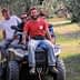 Four men riding on an all-terrain vehicle in an olive grove. - Olive Oil Times