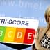 A woman presenting a Nutri-Score sign with ratings from A to E in various colors. - Olive Oil Times