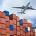 An airplane flying above a stack of colorful shipping containers at a port. - Olive Oil Times