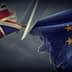 Scissors cutting through a torn British flag and a European Union flag. - Olive Oil Times