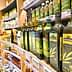 Various bottles of olive oil displayed on a shelf in a grocery store. - Olive Oil Times